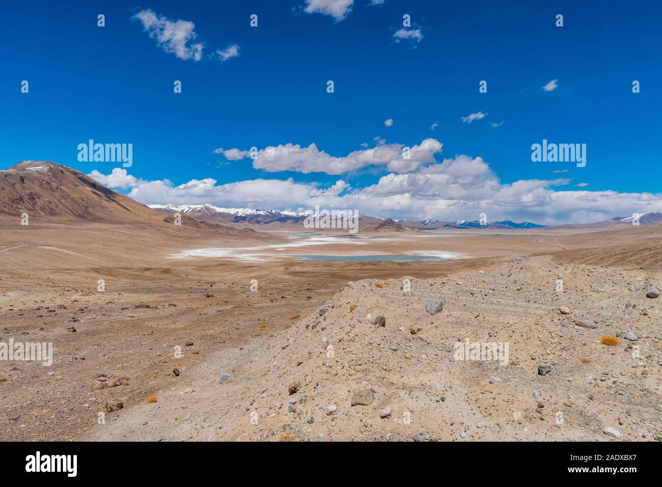 Pamir autostrada M41 Chukurkul sul lago con una vista pittoresca delle montagne innevate su una soleggiata cielo blu giorno Foto Stock