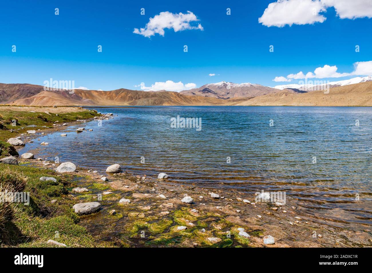 Pamir autostrada M41 Lago Bulunkul con suggestiva vista delle montagne innevate su una soleggiata cielo blu giorno Foto Stock