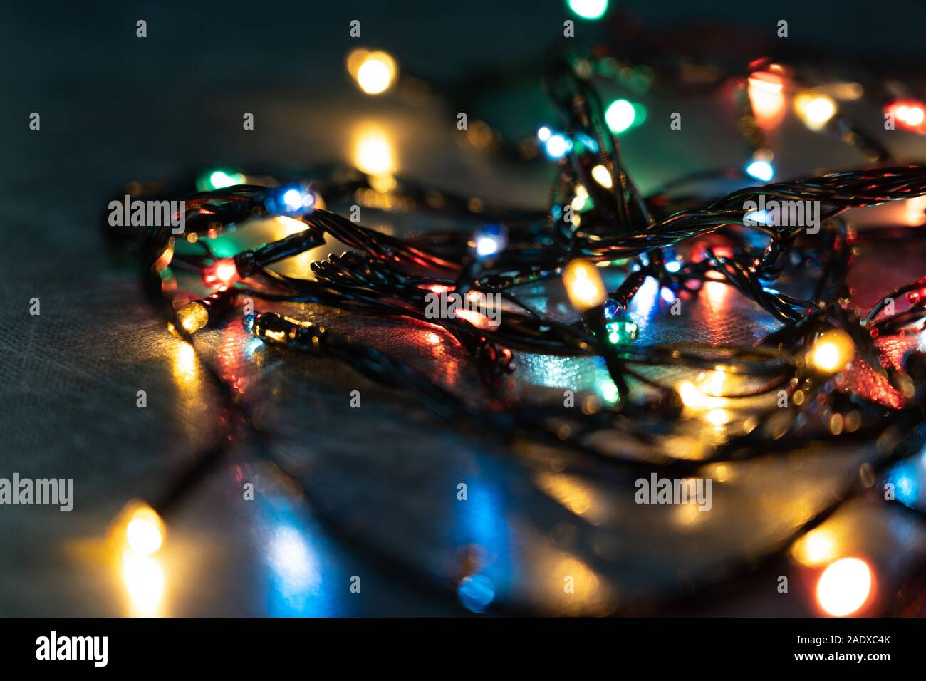 La luce colorata lampadine ad incandescenza sul tavolo al buio. Copia dello  spazio. Incandescente le luci di Natale sul tavolo, primo piano Foto stock  - Alamy