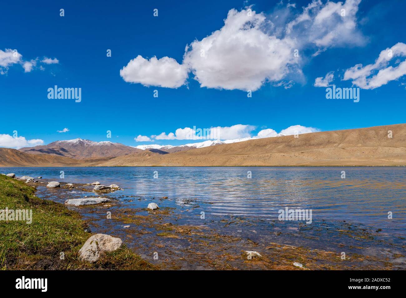 Pamir autostrada M41 Lago Bulunkul con suggestiva vista delle montagne innevate su una soleggiata cielo blu giorno Foto Stock