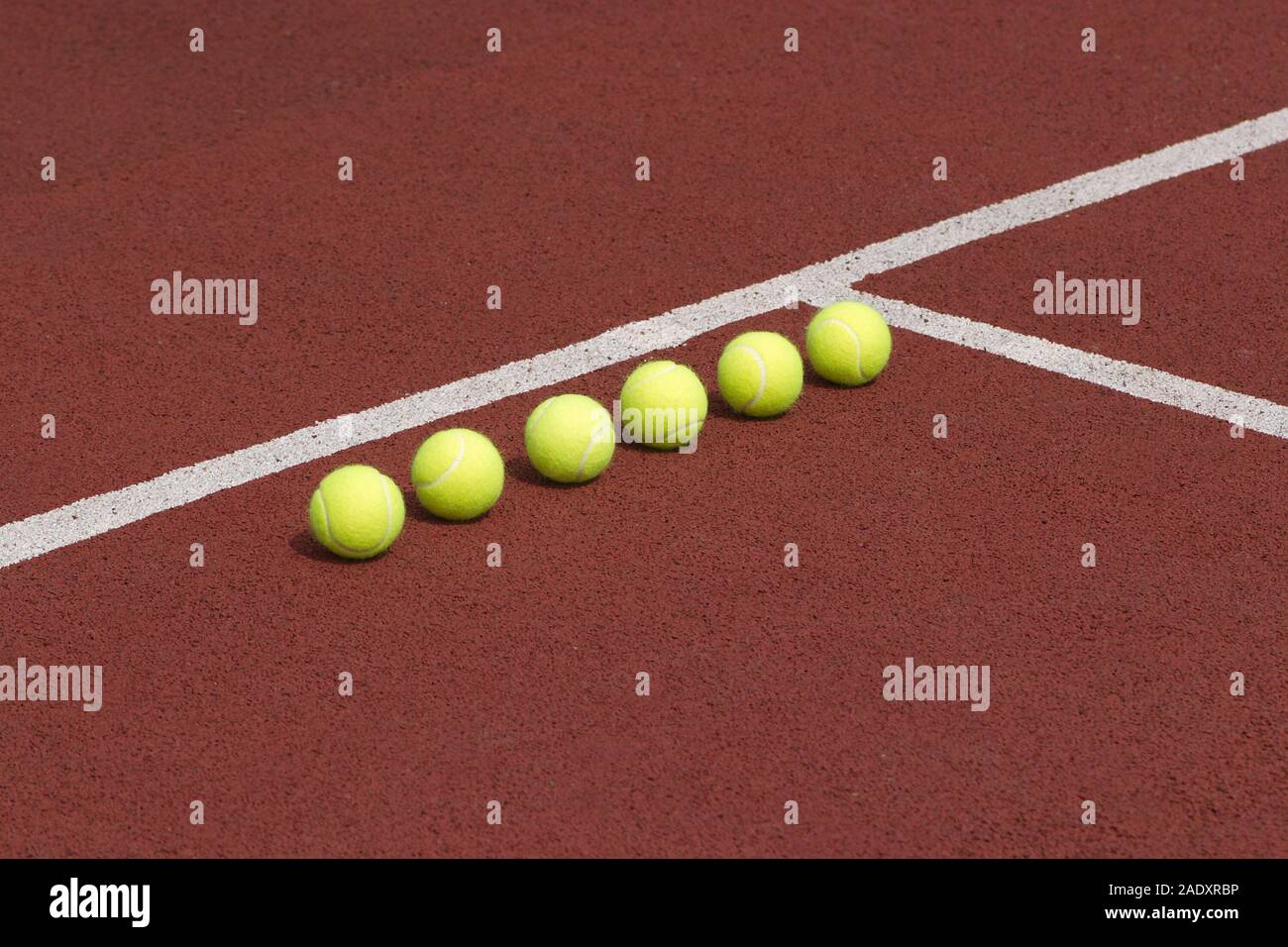 Linea di sei giallo le palline da tennis su corte vista laterale Foto Stock