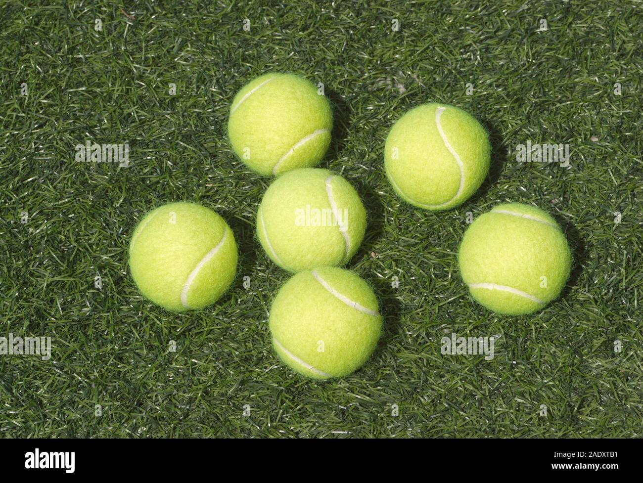 Sei giallo palle da tennis stabilisce su verde erba sintetica vista  frontale Foto stock - Alamy