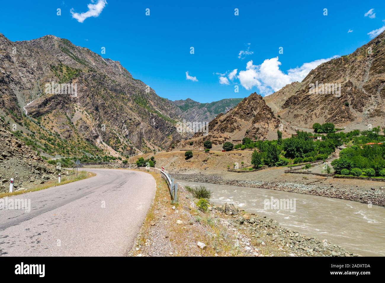 Per Kulob Qalai Khumb Pamir Highway pittoresco Fiume Panj Valley View di un villaggio afghano su un soleggiato Blue Sky giorno Foto Stock