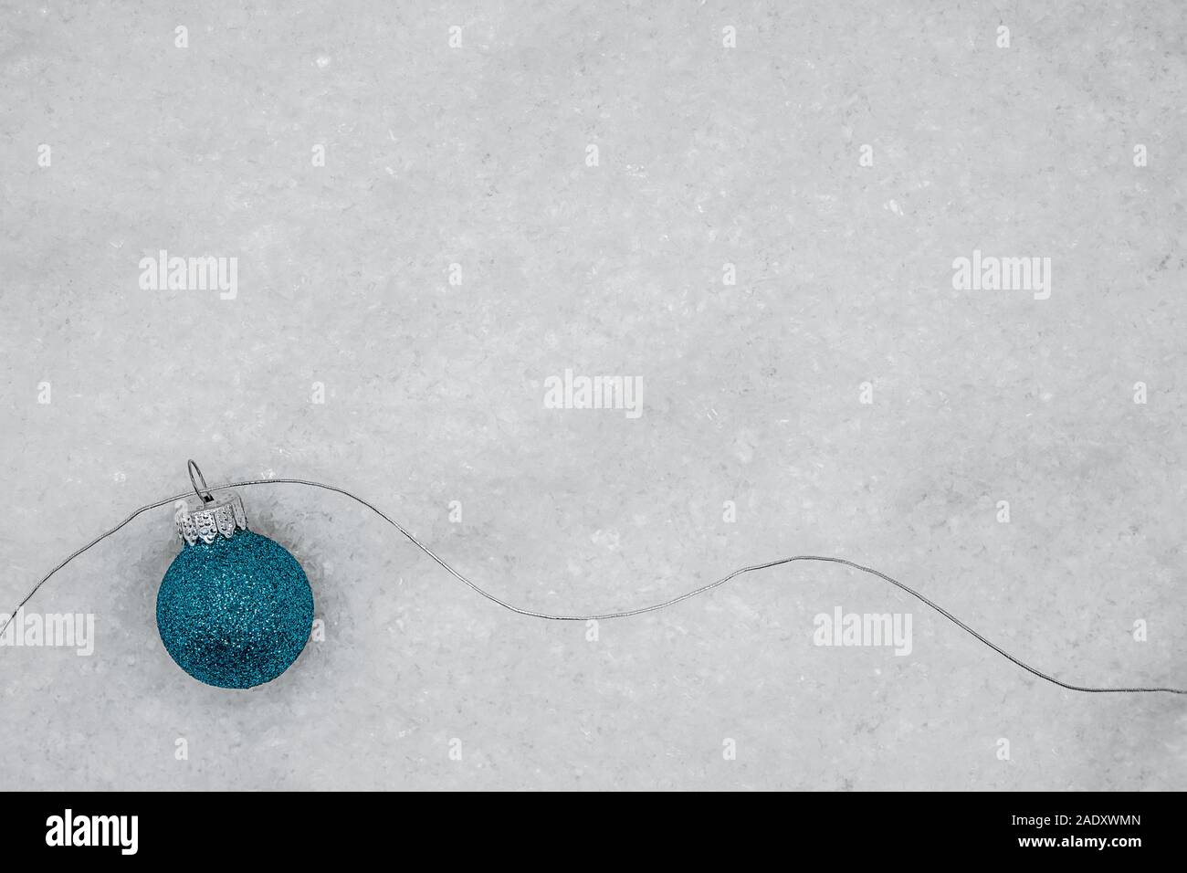 Il blu scintillante palla di Natale con filo di argento sulla neve Foto Stock