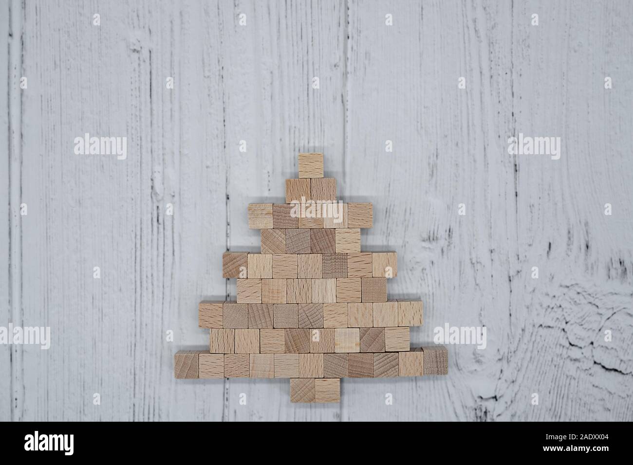 Albero di Natale fatto di piccoli cubi di legno sul pannello di legno Foto Stock