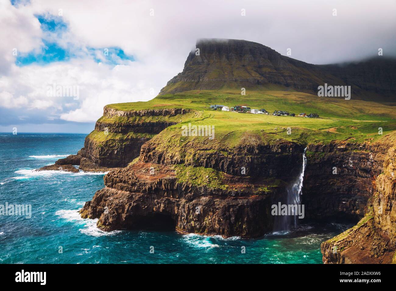 Gasadalur villaggio e la sua leggendaria cascata sotto il forte vento, funzionario ministeriale, Isole Faerøer, Danimarca Foto Stock