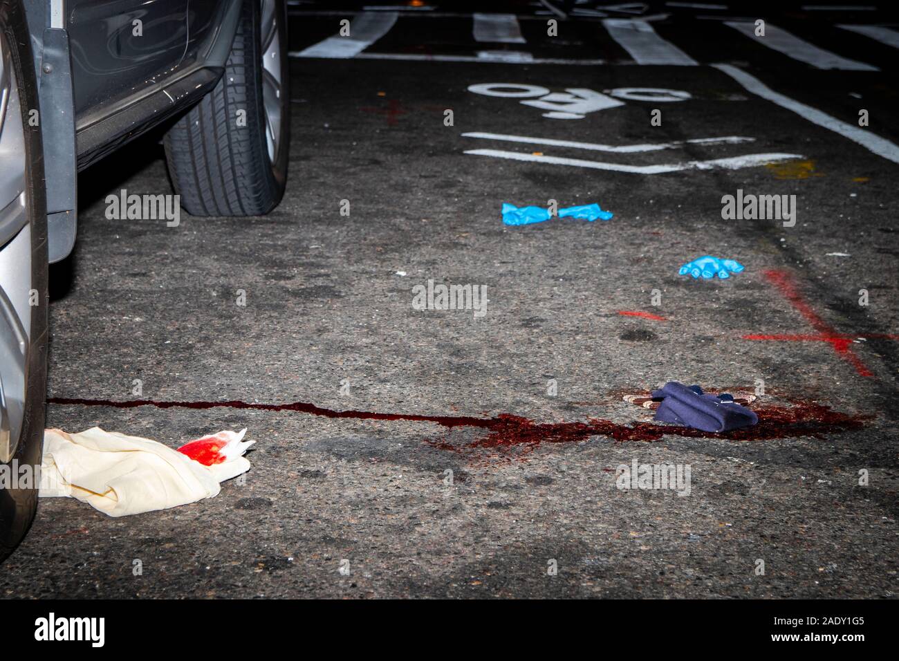Macchie di sangue sulla strada di New York City, accanto a scartare i guanti in lattice e sangue stracci imbevuti Foto Stock