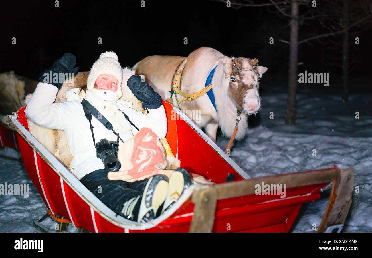 Ragazza in sella la renna slitta in inverno Rovaniemi riflesso di notte Foto Stock