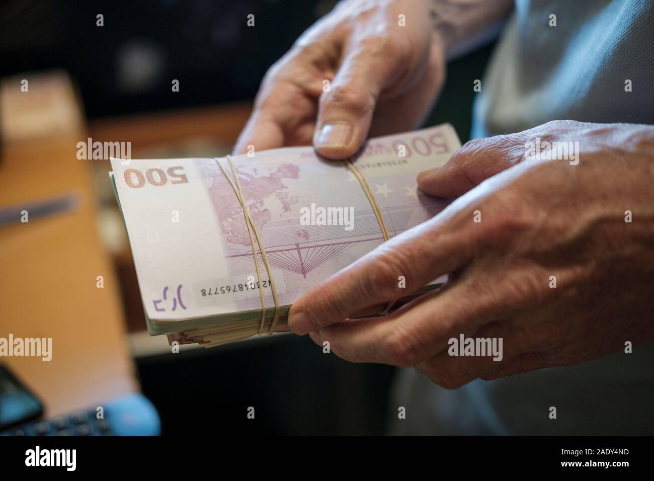 Chi detiene un batuffolo di contanti, le banconote in euro - il fuoco selettivo Foto Stock