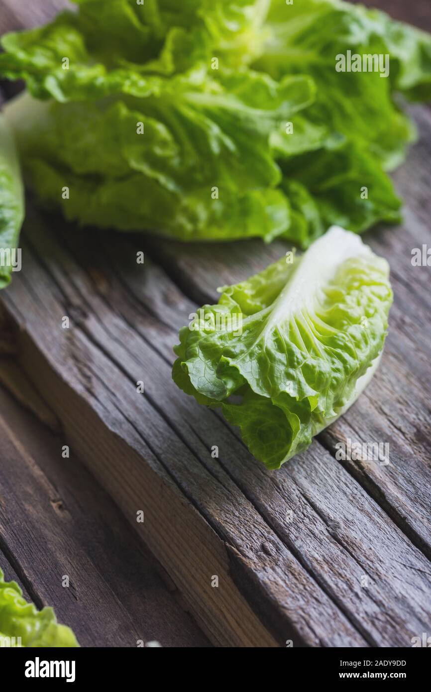 Freschi di lattuga sulla tavola di legno. Vegano sano impianto basato il cibo sulla tavola in legno rustico Foto Stock