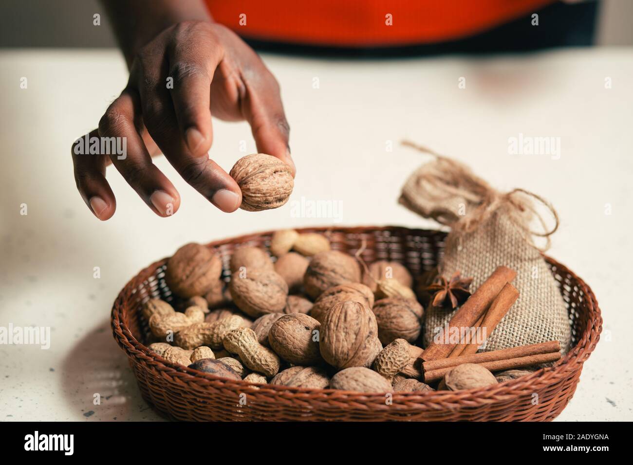 Uomo di contenimento con cautela in noce le dita sopra il cestello Foto Stock