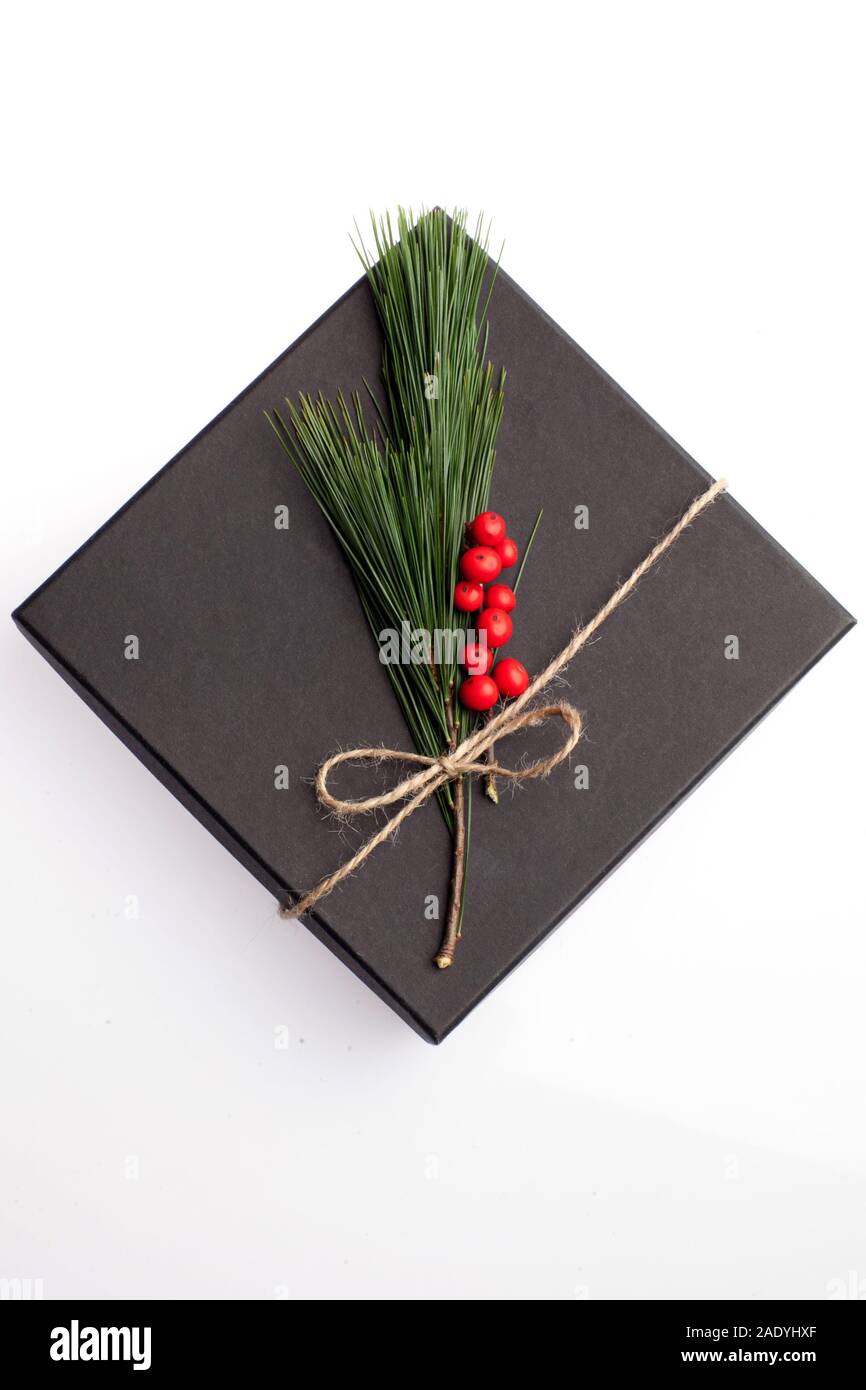 Black Box presente decorate con elementi floreali, agrifoglio e pino ramo con corda naturale nastro. Dono adatto per Natale, compleanno, Valentin Foto Stock