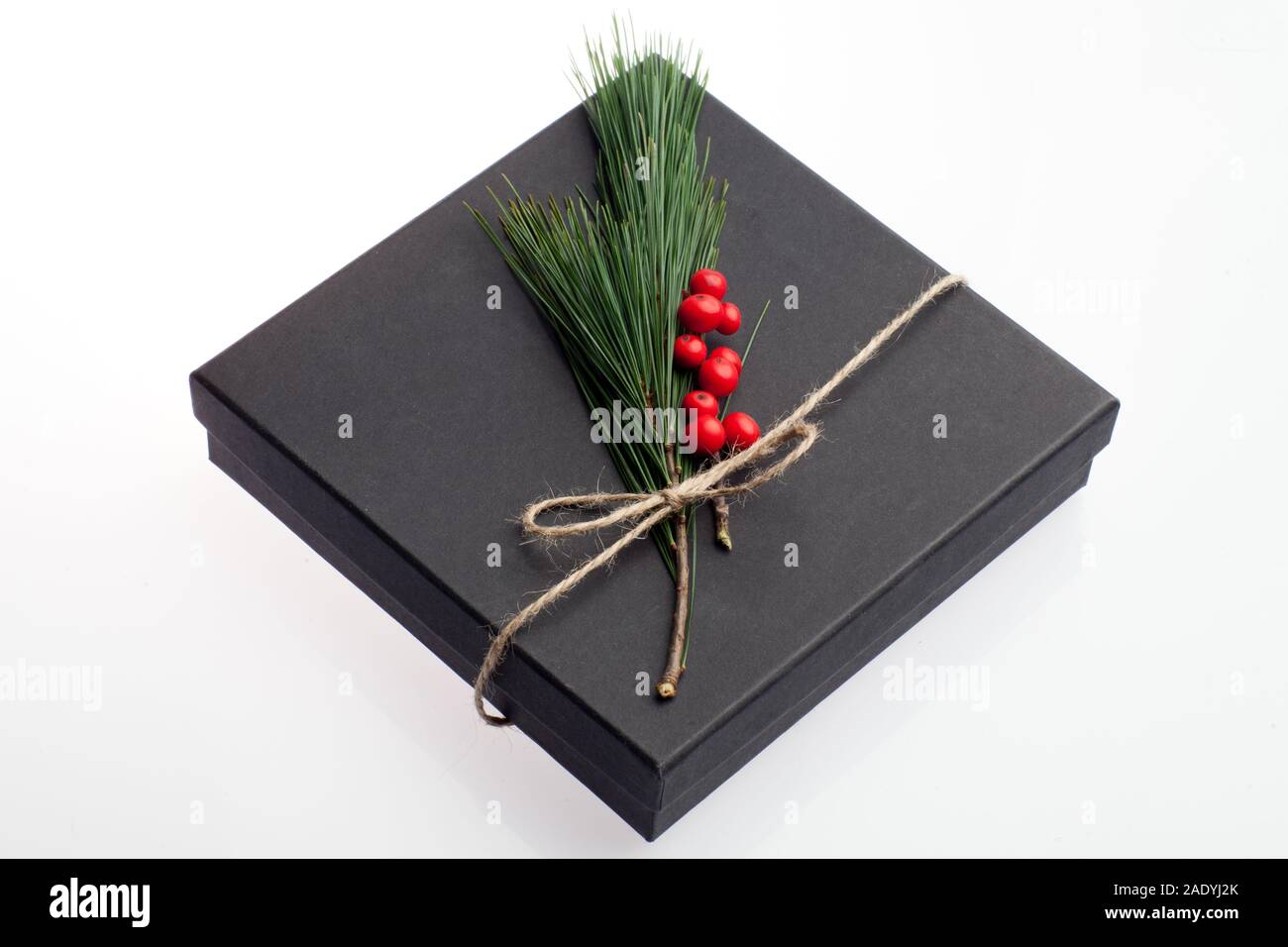 Black Box presente decorate con elementi floreali, agrifoglio e pino ramo con corda naturale nastro. Dono adatto per Natale, compleanno, Valentin Foto Stock