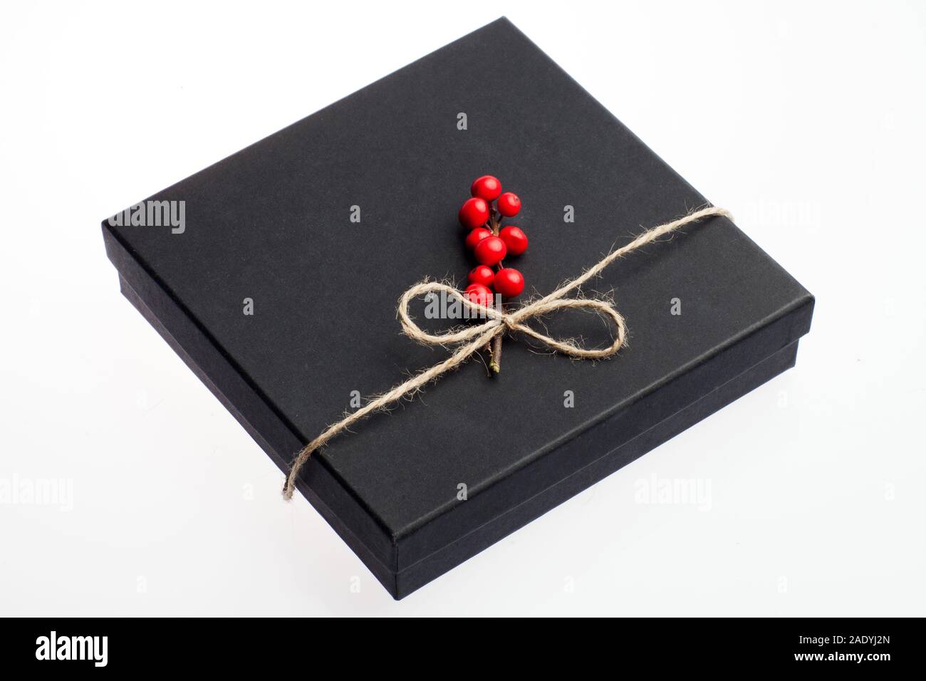 Black Box presente decorate con elementi floreali, holly ramo con una corda naturale nastro. Dono adatto per Natale, compleanno, il giorno di San Valentino Foto Stock