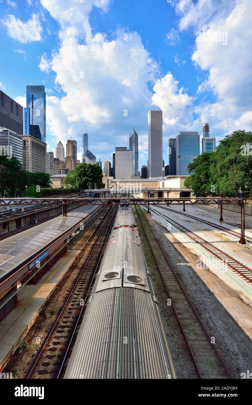 Chicago, Illinois, Stati Uniti d'America. Il treno dei pendolari che arrivano a Van Buren Street Station con un segmento dello skyline della città che sovrasta in background. Foto Stock