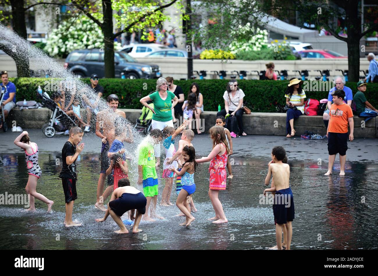 Chicago, Illinois, Stati Uniti. I bambini giocano e si rinfrescano alla Crown Fountain nel Millennium Park di Chicago in una calda giornata estiva. Foto Stock