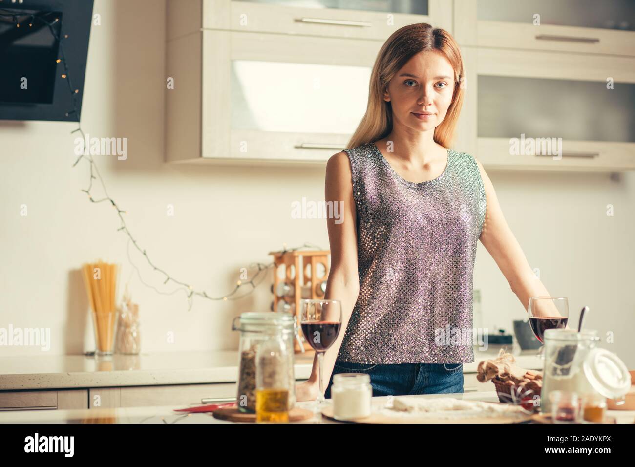 Attraente dama in vacanza vestiti in piedi in cucina da solo Foto Stock