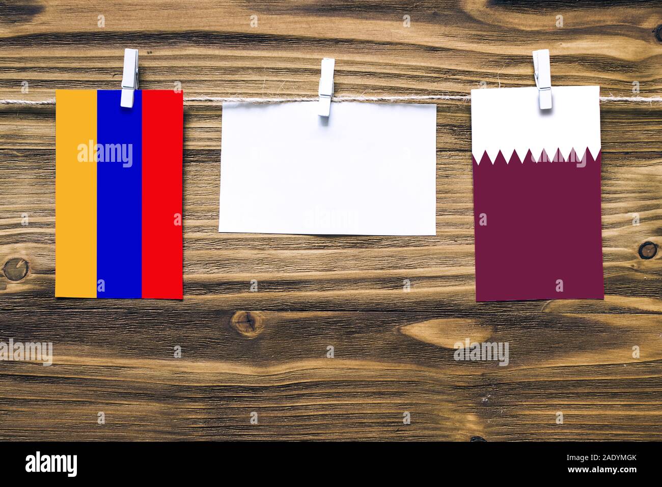 Appendere bandiere di Armenia e il Qatar attaccata alla corda con vestiti perni con copia spazio bianco sulla nota carta su sfondo di legno.Le relazioni diplomatiche essere Foto Stock