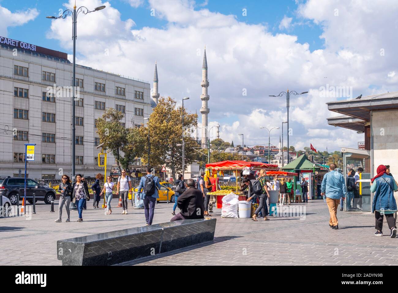Un fornitore vende carni cotte sulla pannocchia di mais sulla strada di fronte al Ponte di Galata come locali turchi passano ad Istanbul in Turchia. Foto Stock