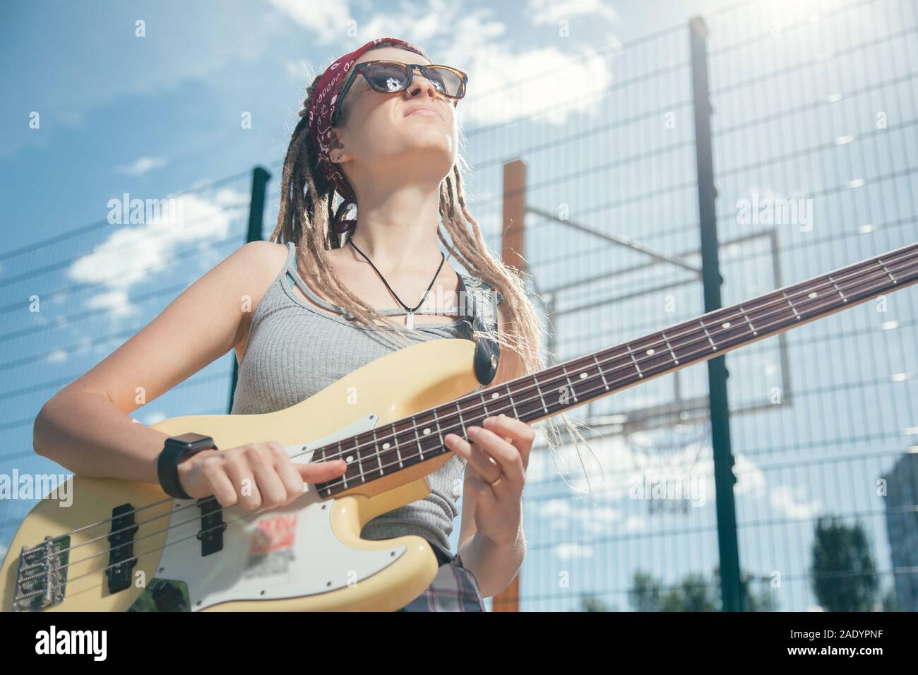 Musicista di talento accigliata mentre suona la chitarra in giornata di sole Foto Stock