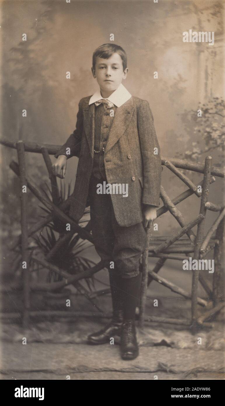 Vintage inizio del XX secolo British Photographic Studio Postcard mostra un  giovane ragazzo elegantemente vestito Foto stock - Alamy