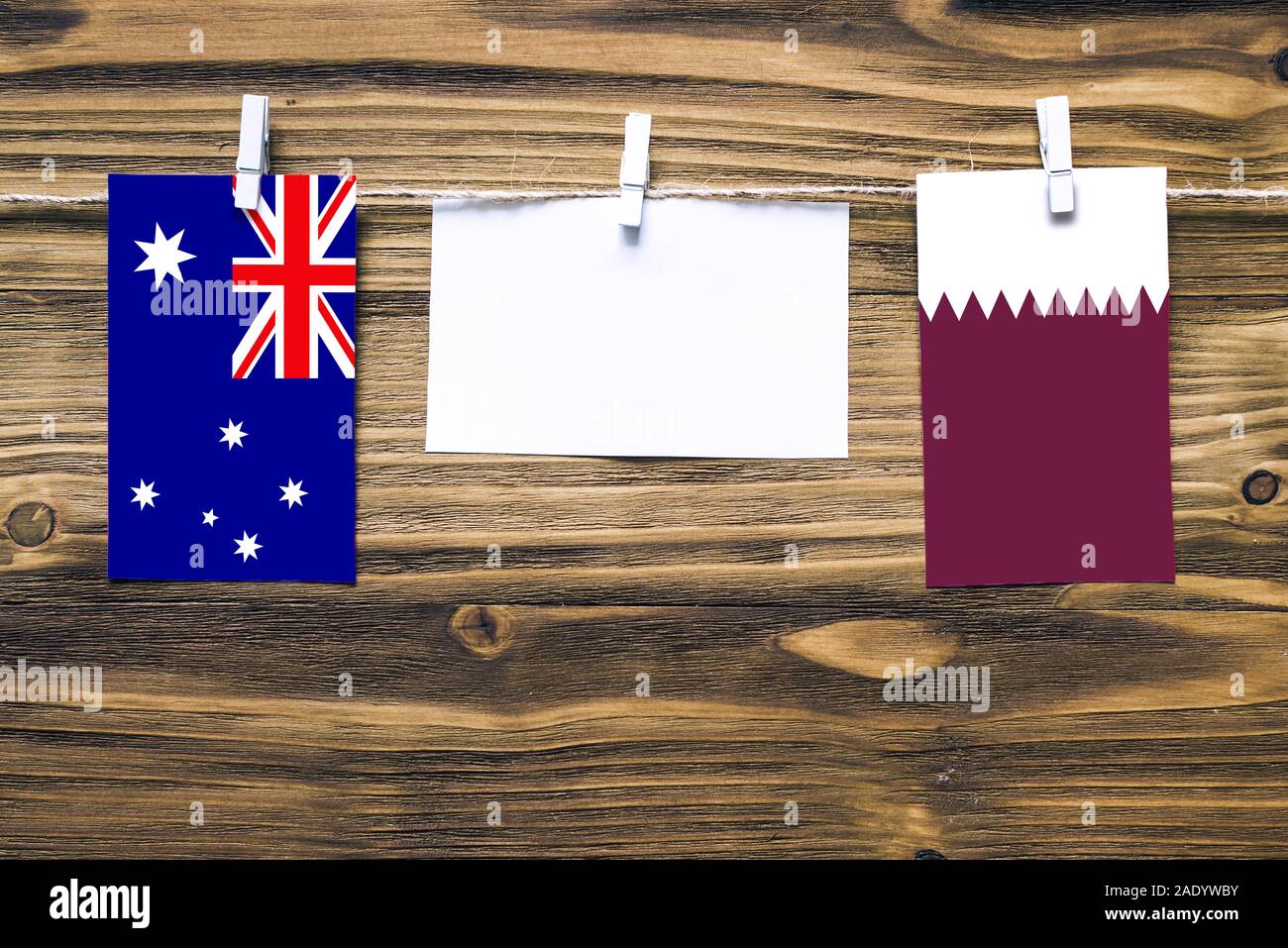 Appendere bandiere di Australia e Qatar attaccata alla corda con vestiti perni con copia spazio bianco sulla nota carta su sfondo di legno.Le relazioni diplomatiche Foto Stock