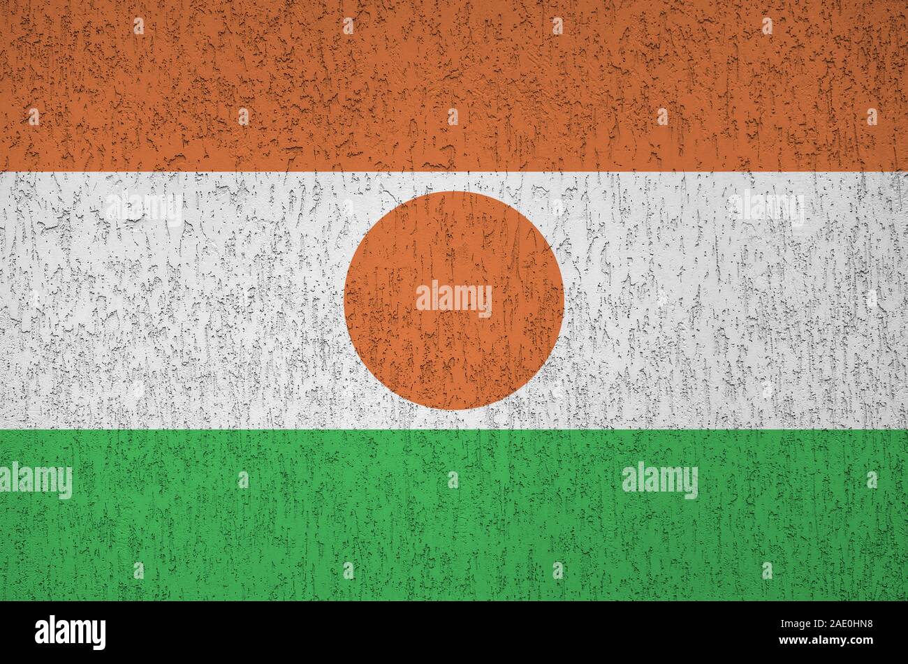 Niger bandiera rappresentata in luminosi colori di vernice su vecchi intonaci a rilievo parete vicino. Textured banner su sfondo irregolare Foto Stock