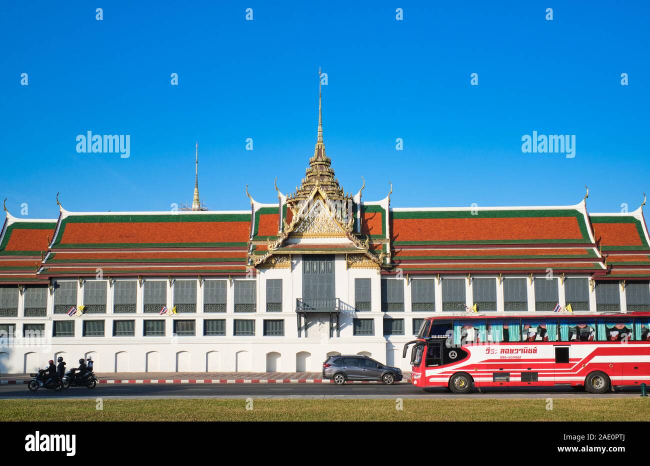 Parte del Wat Phra Kaew & Grand Palace complesso in Bangkok, Thailandia, visto da Sanam Chai Road, con una rosa autobus turistico passando davanti Foto Stock