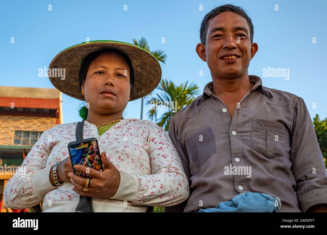 Ritratto di un territorio rurale di birmani giovane girato dal di sotto. Indossa una tradizionali asiatici dell'agricoltore cappello conico e i suoi denti sono di colore rosso da Betel il dado. Foto Stock