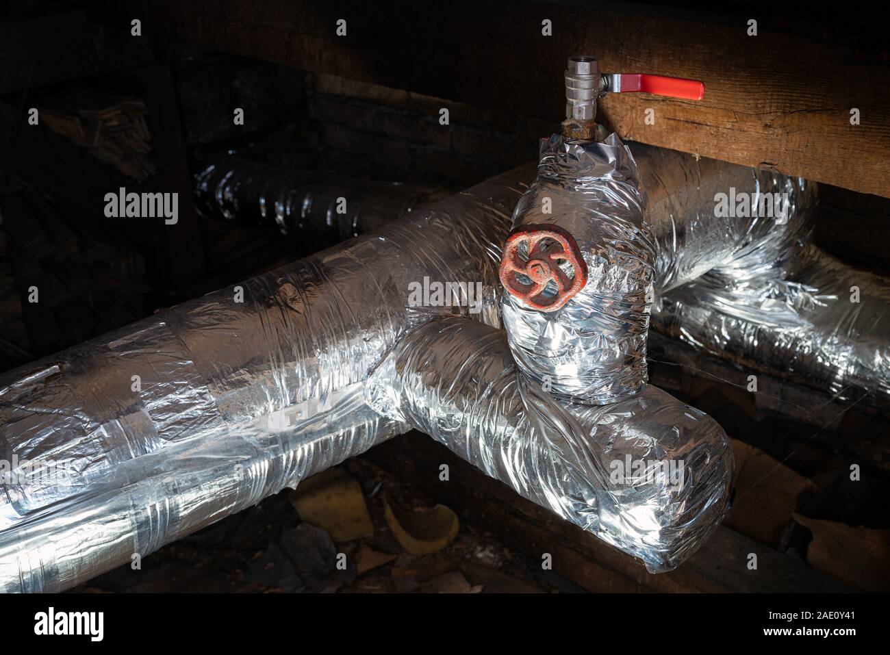 Argento vecchio centro di tubi di riscaldamento in camera oscura per interni. Metallo vecchia caldaia di riscaldamento di generazione e di consegnarla a casa tramite pipeline Foto Stock