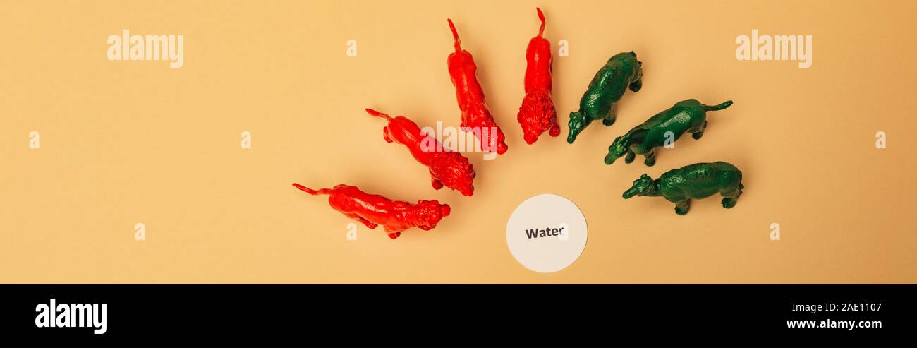 Panoramica di animali di giocattolo con caratteri di acqua sulla carta su sfondo giallo, la carenza di acqua concetto Foto Stock