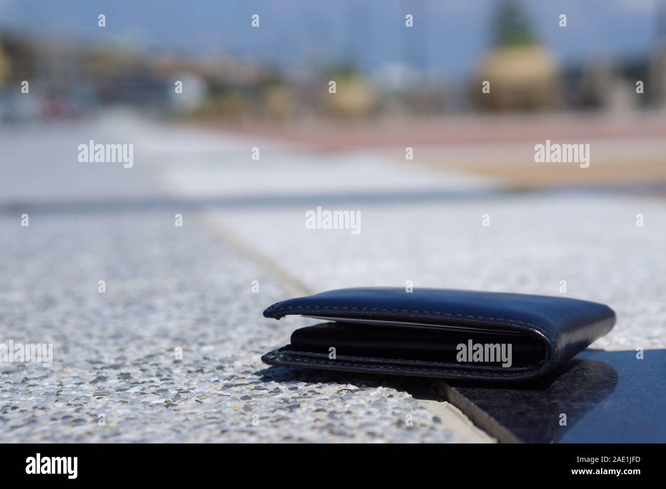 Closeup perso nero portafoglio in pelle con caduta di denaro sul sentiero, perso il concetto di denaro Foto Stock