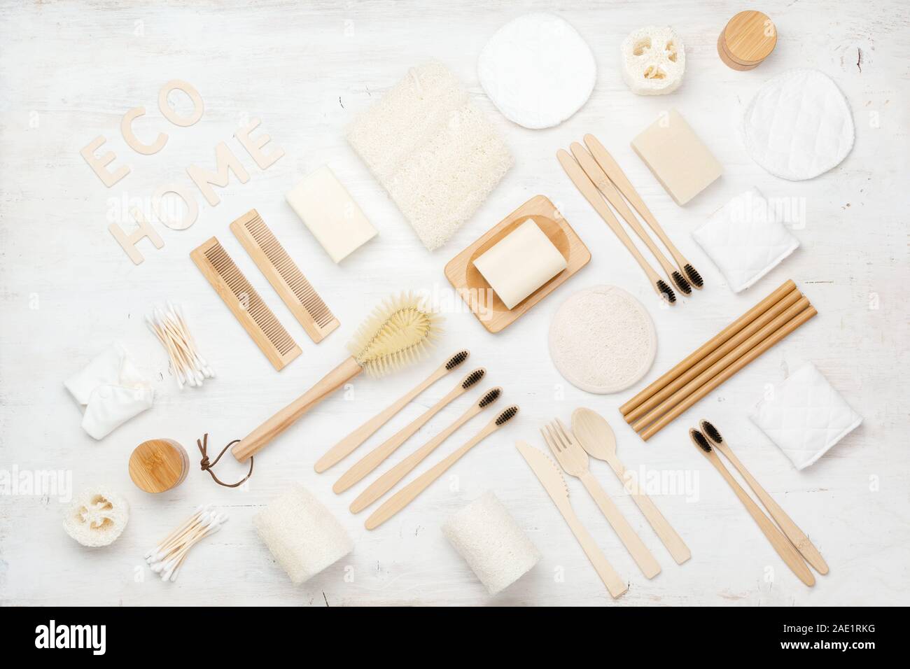 Eco concetto vivente, Creative flatlay naturale con accessori biodegradabili. Gli spazzolini da denti di bambù, sapone artigianale shampoo bar, batuffoli di cotone pastiglie, prodotti di igiene la luffa su bianco, vista dall'alto Foto Stock