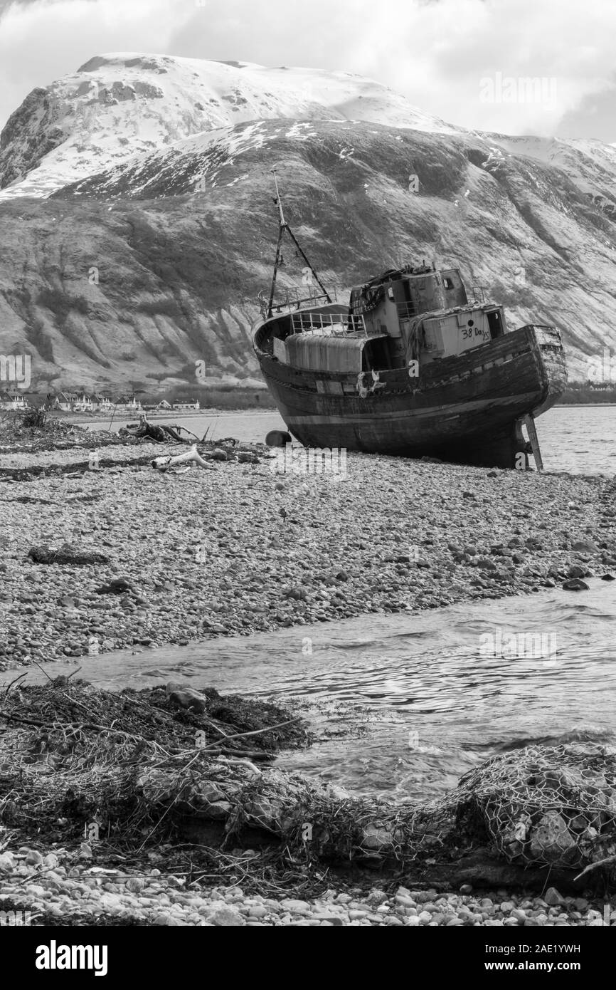 Il relitto della MV Dayspring barca con il Ben Nevis dietro, Corpach, Fort William, Inverness, Highlands scozzesi, Scotland, Regno Unito in marzo - monocromatico B&W Foto Stock