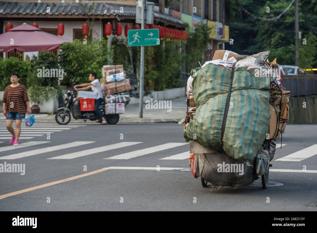 Chengdu, Cina - Luglio 2019 : Persona che trasporta un carico pesante per le strade della città di Chengdu in estate, nella provincia di Sichuan Foto Stock