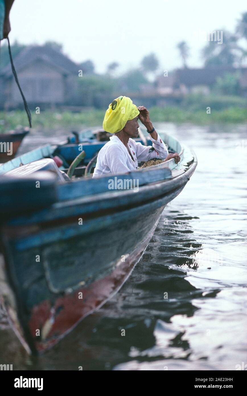 Indonesia. Borneo. A sud di Kalimantan. Fiume Barito. Vista laterale della vecchia donna seduta in barca open. Foto Stock