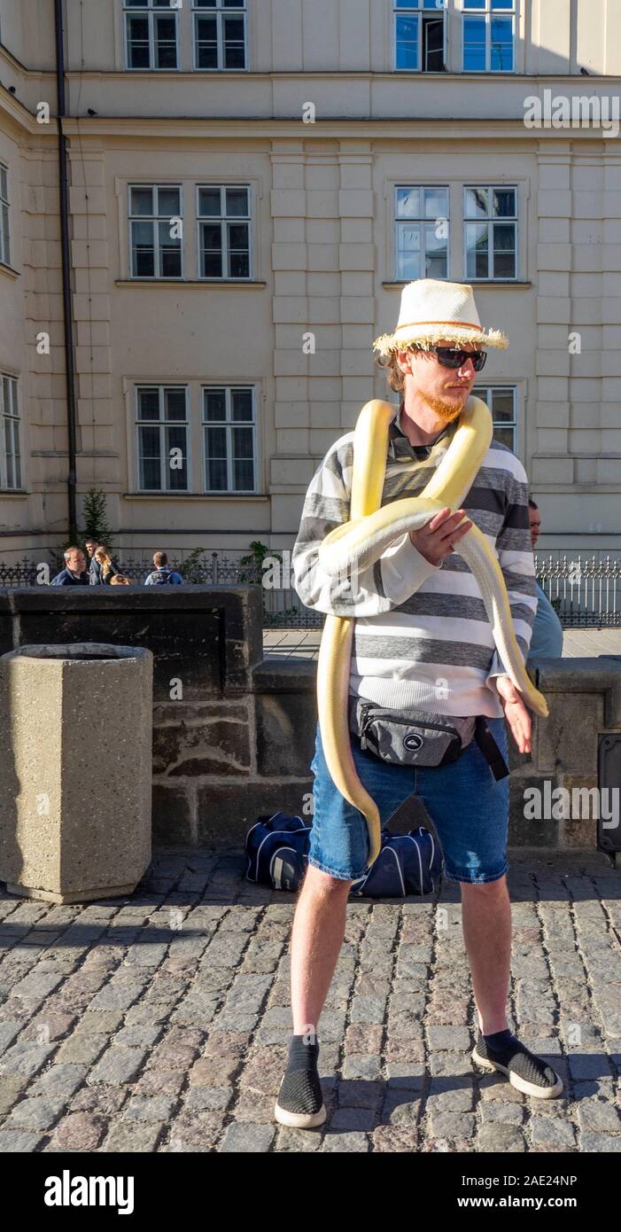 Charles Bridge tout maschio con python snake per i turisti per scattare fotografie con, Praga Repubblica Ceca. Foto Stock