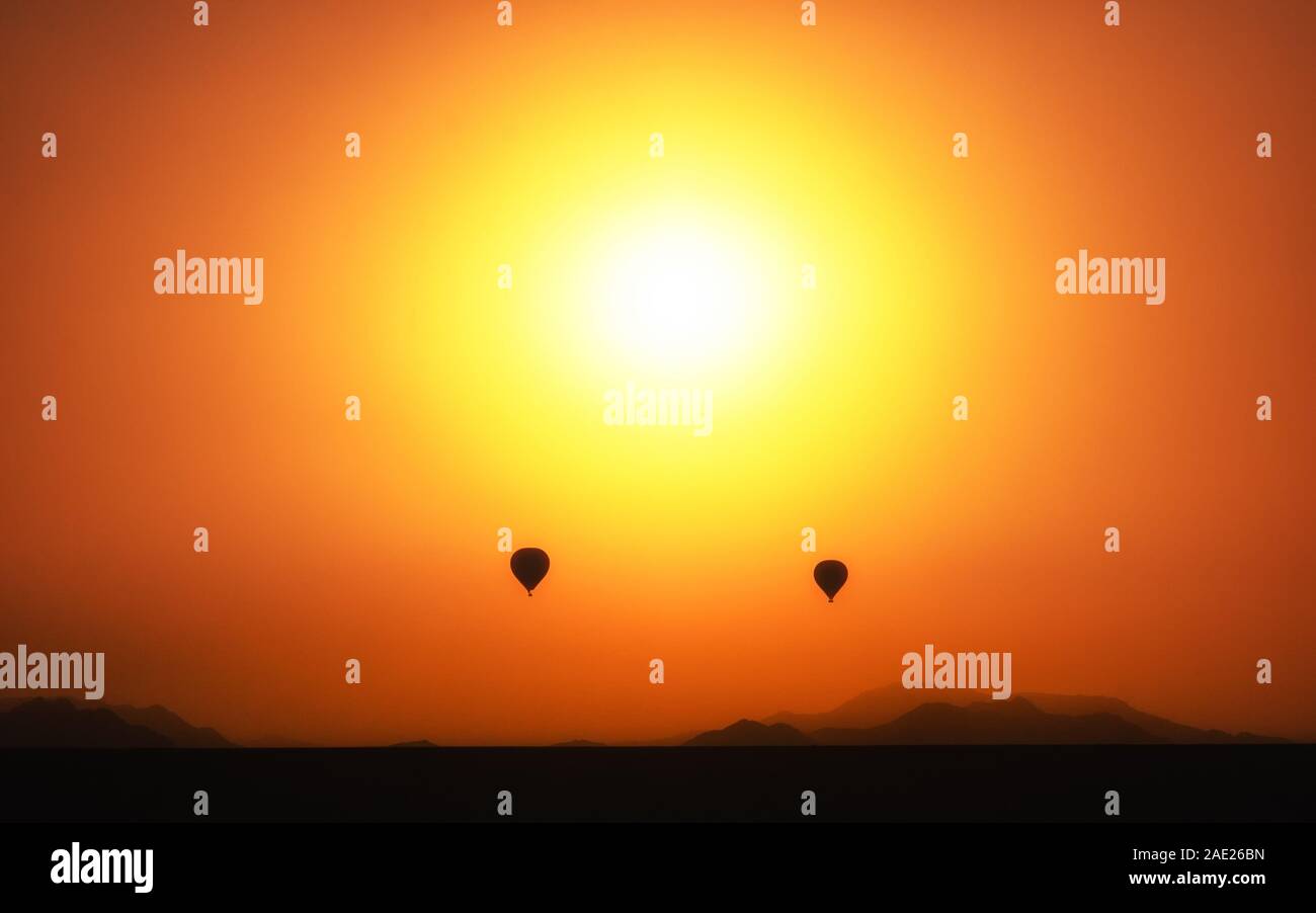 2 palloncini di fronte al tramonto nel deserto Foto Stock