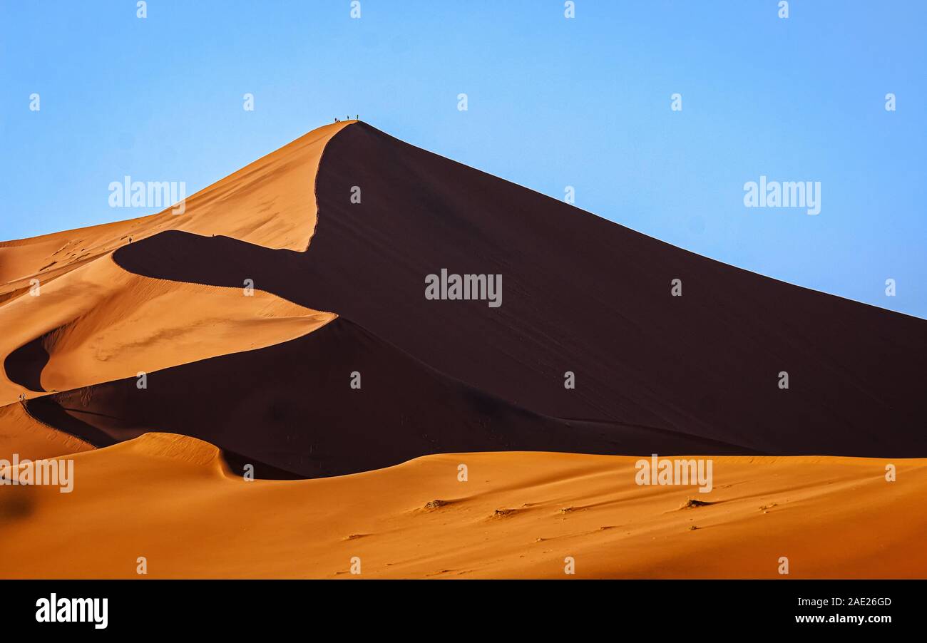 Deserto Namibiano dune linee perfette e shoadows con persone di salire Foto Stock