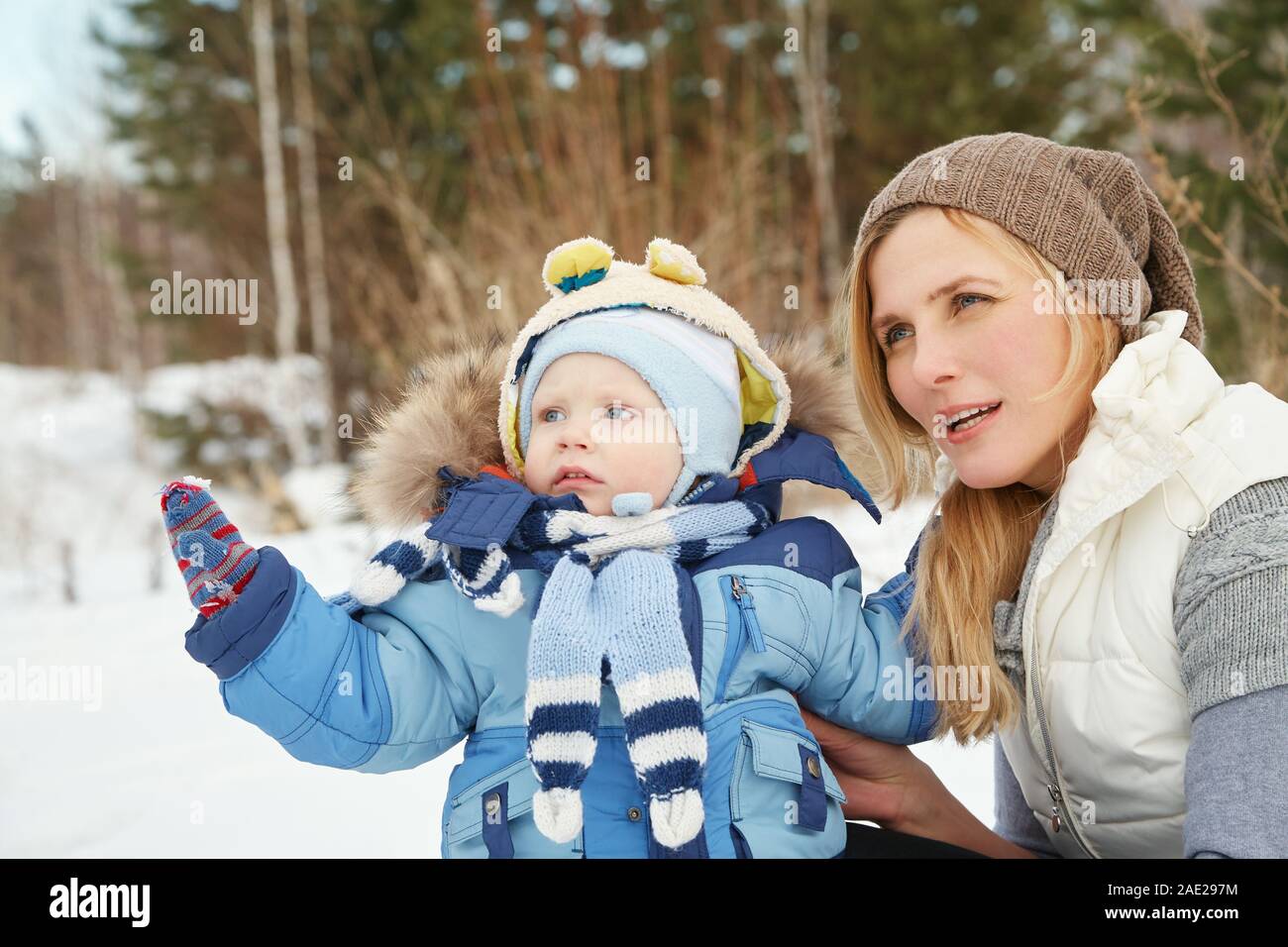 Felice la madre e il bambino in winter park. famiglia all'esterno. allegro mamma con il suo bambino Foto Stock
