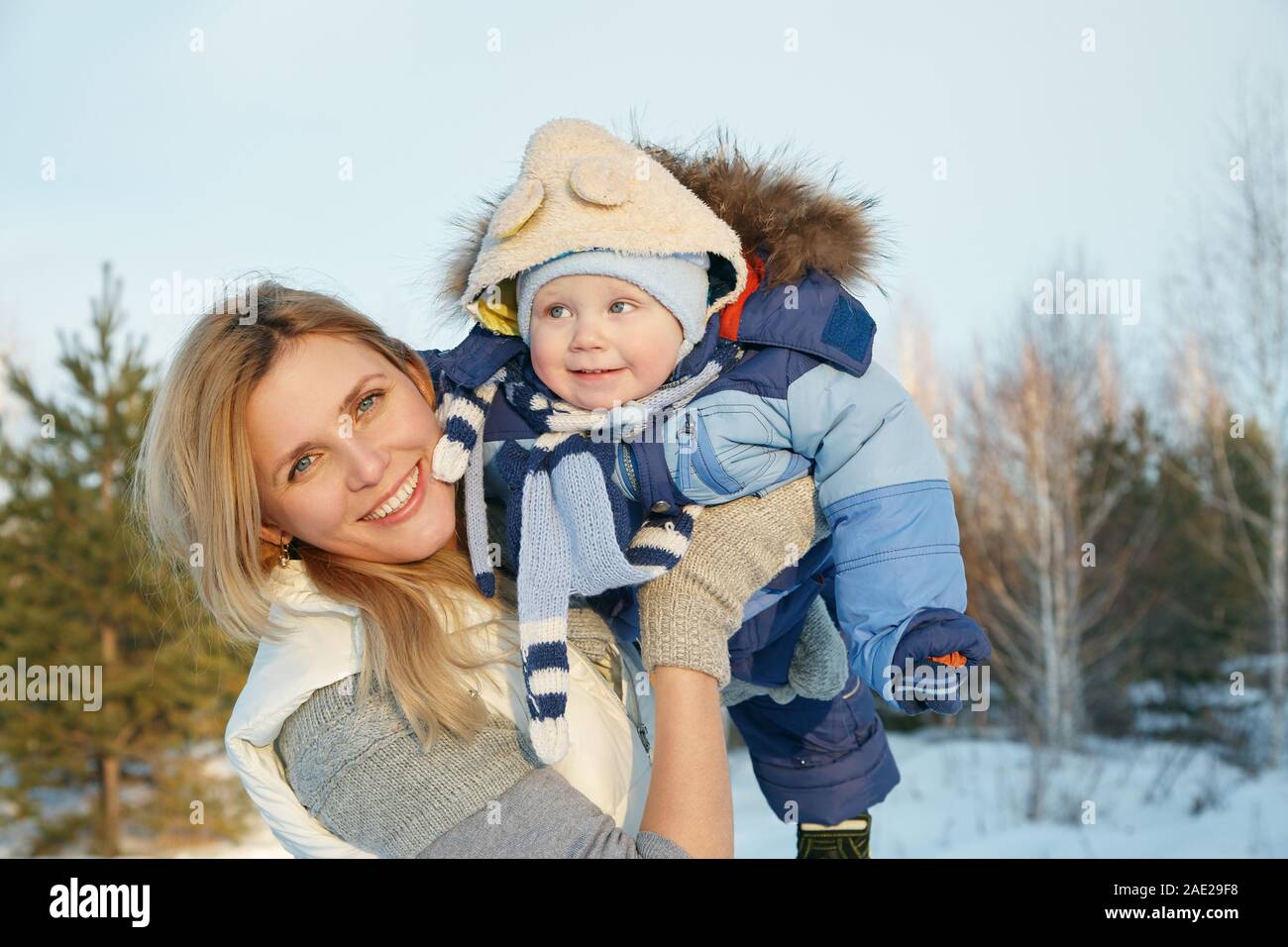 Felice la madre e il bambino in winter park. famiglia all'esterno. allegro mamma con il suo bambino Foto Stock