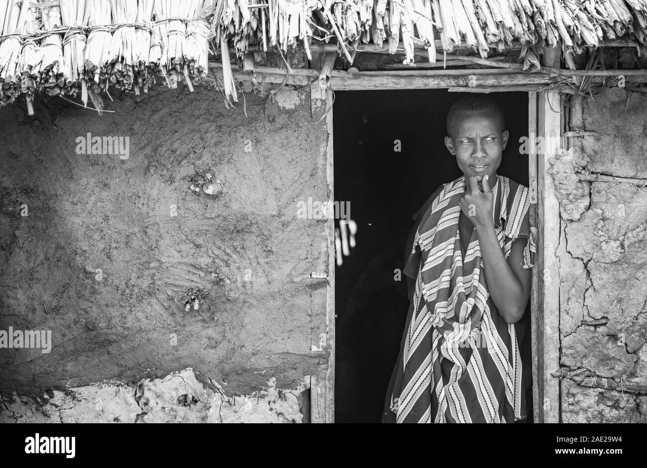 Stesso, Tanzania, 6 Giugno 2019: Maasai donna che guarda fuori la sua porta Foto Stock