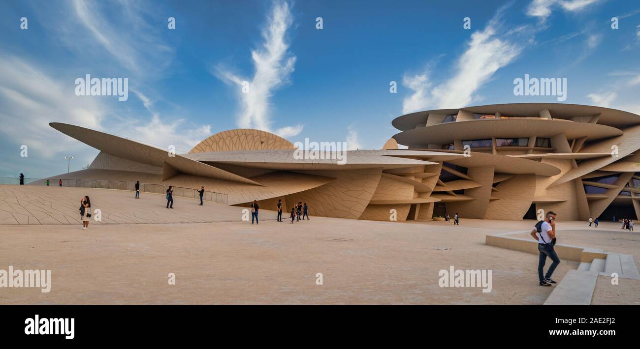 Museo Nazionale del Qatar (Desert Rose) vista esterna del giorno con persone che camminano e scattano foto e nuvole nel cielo in background Foto Stock
