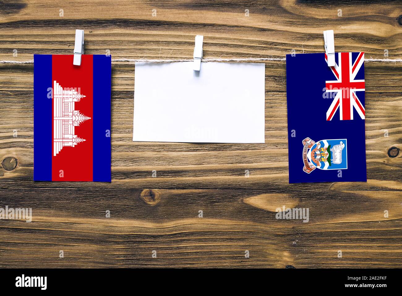 Appendere bandiere della Cambogia e Isole Falkland attaccata alla corda con vestiti perni con copia spazio bianco sulla nota carta su sfondo di legno.Diplomatic Foto Stock