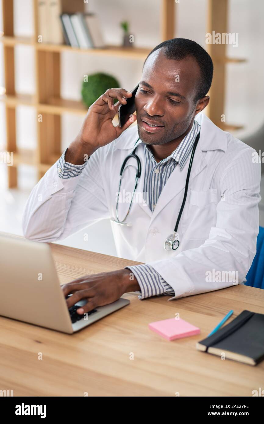 Occupato lavoratore medico essendo in ufficio Foto Stock