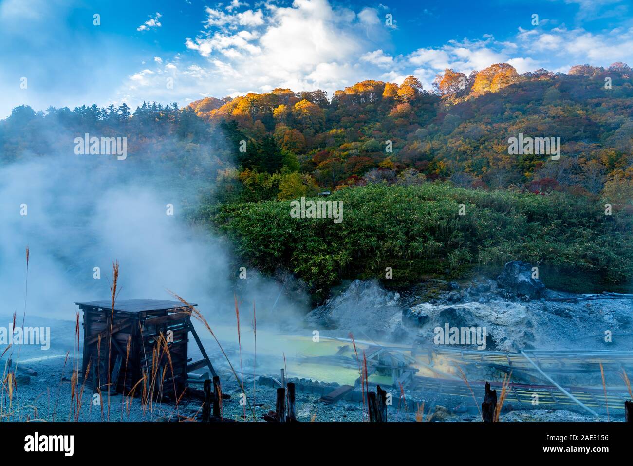 Vista in Tamagawa onsen al mattino con la luce del sole risplendere sul colorato fogliame di autunno foresta sul Monte Bianco e il flusso di vapore di acqua calda sul Foto Stock