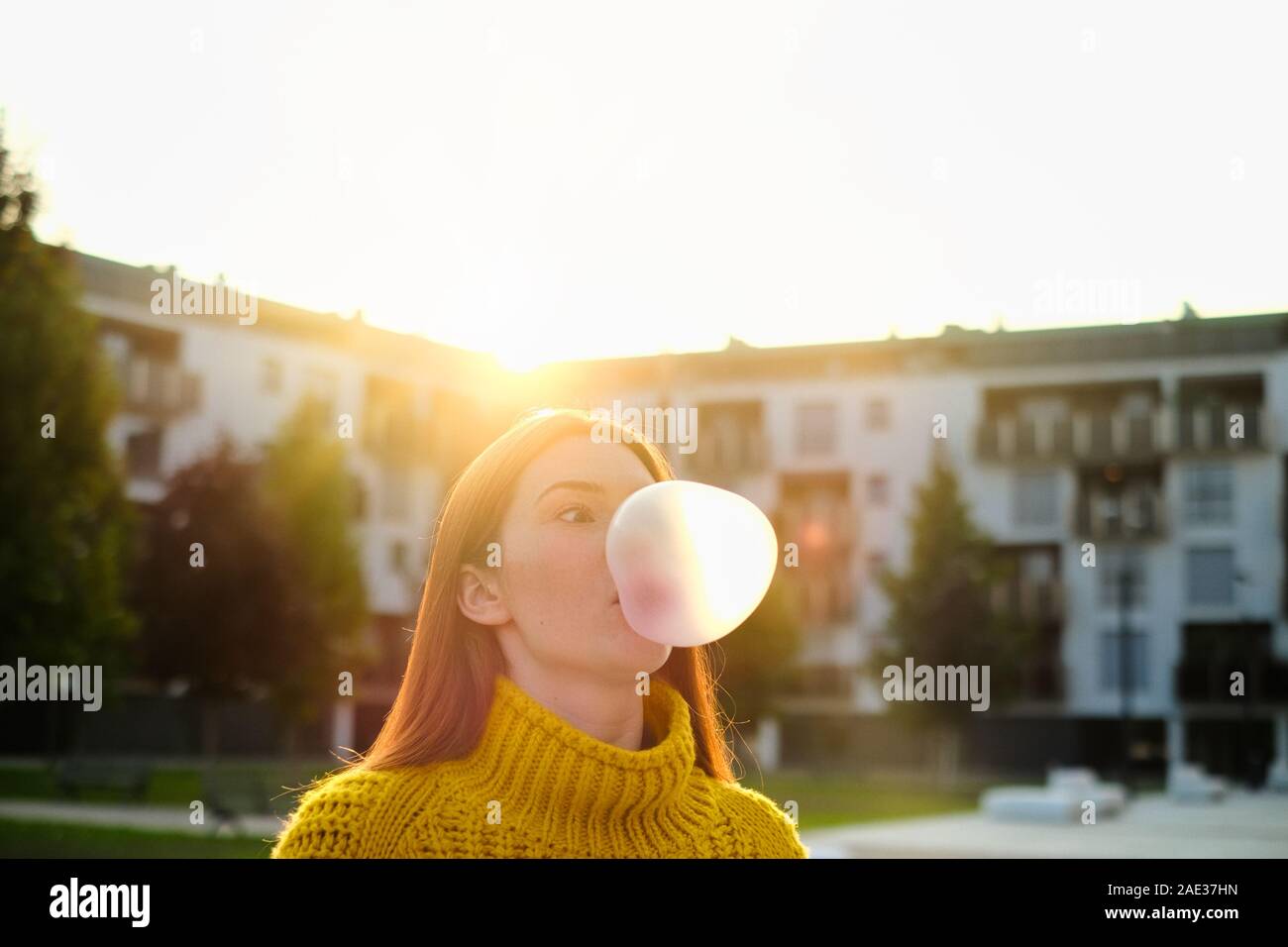 Giovane donna di chewing gum e rendere grande mongolfiera Foto Stock