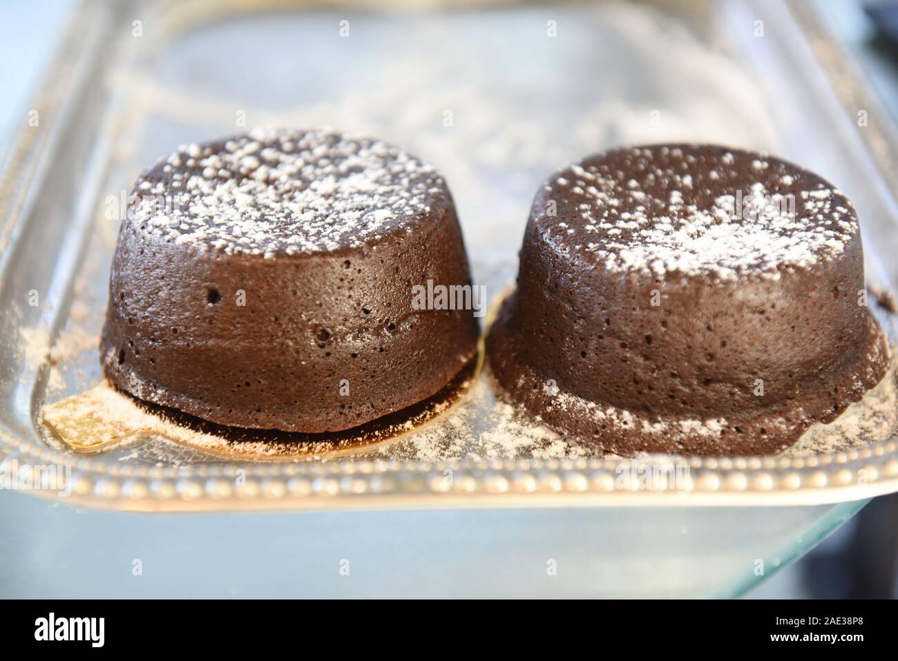 Singoli cioccolato torta di lava spolverato di zucchero a velo Foto Stock