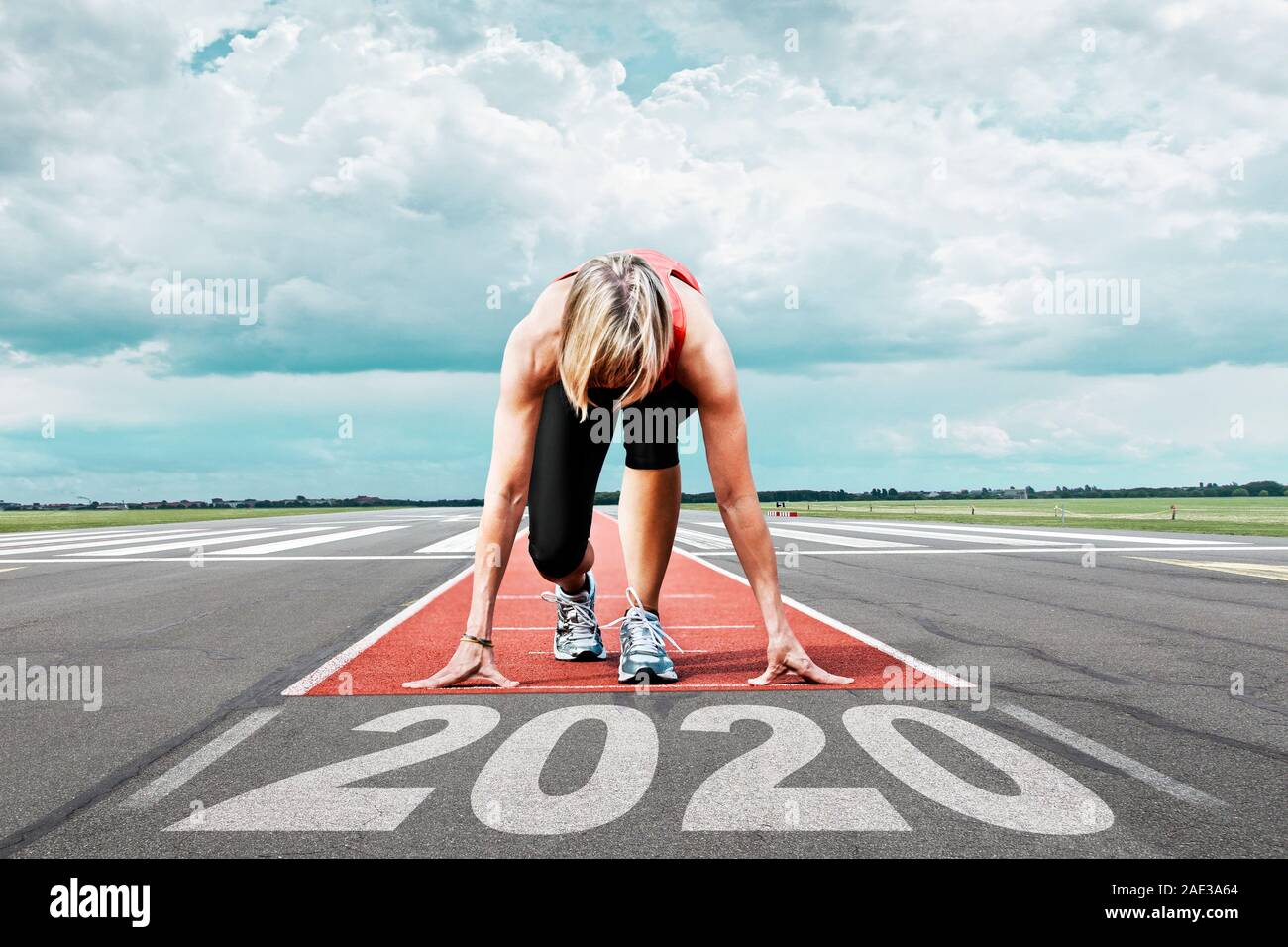 Femminile attende il suo inizio in una pista di aeroporto. In primo piano il dipinto data 2020 simboleggia l'anno. Foto Stock