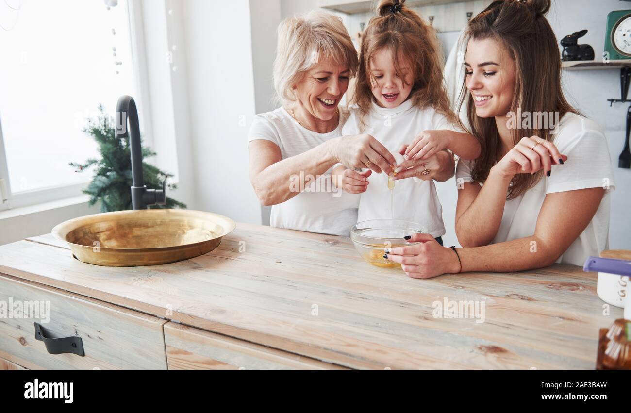 Ben fatto, sei già bene a questo. Madre, la nonna e la figlia avente un buon tempo in cucina Foto Stock